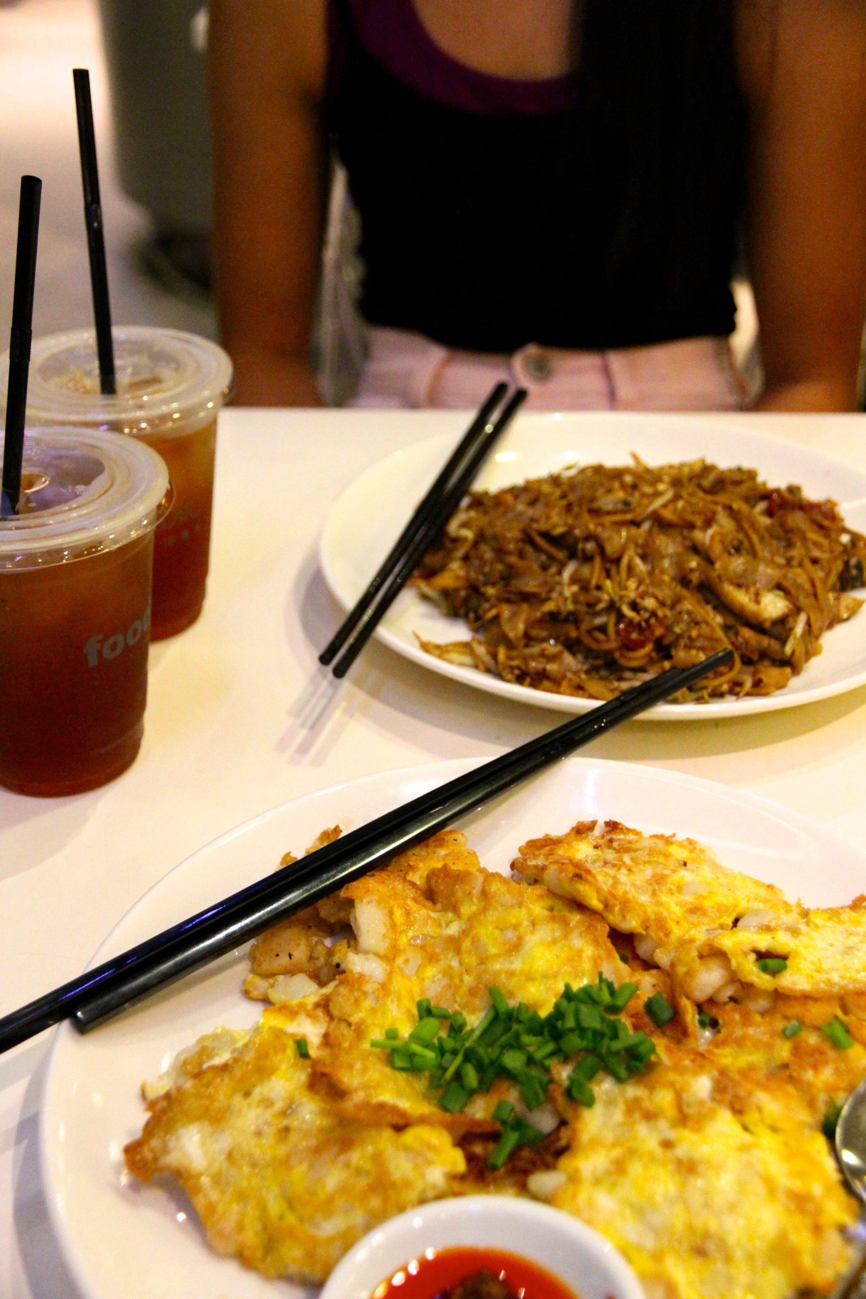 Fried carrot cake in the foreground and Char Kway Teow in the background