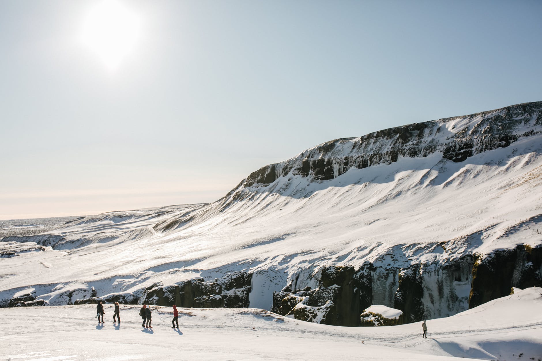 people walking on a snow covered mountain trail