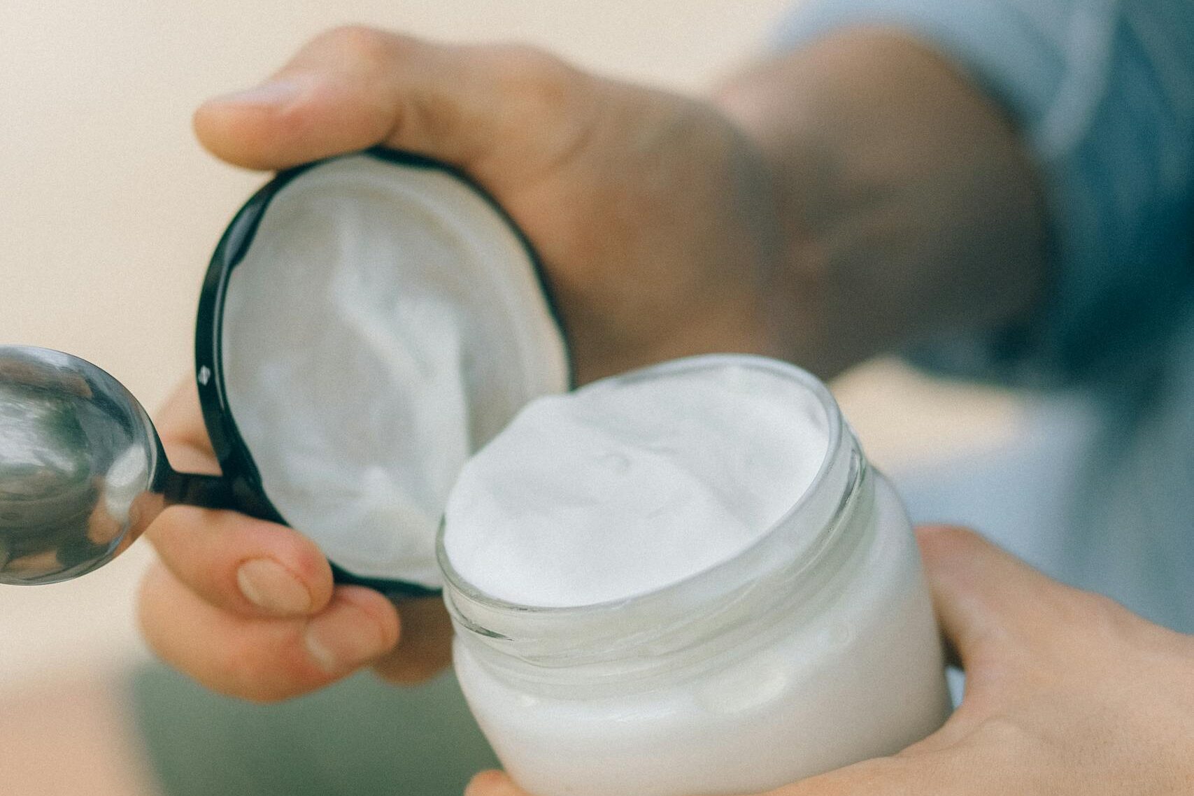 Detailed shot of hands opening a jar of cream, ideal for skincare and natural product concepts.