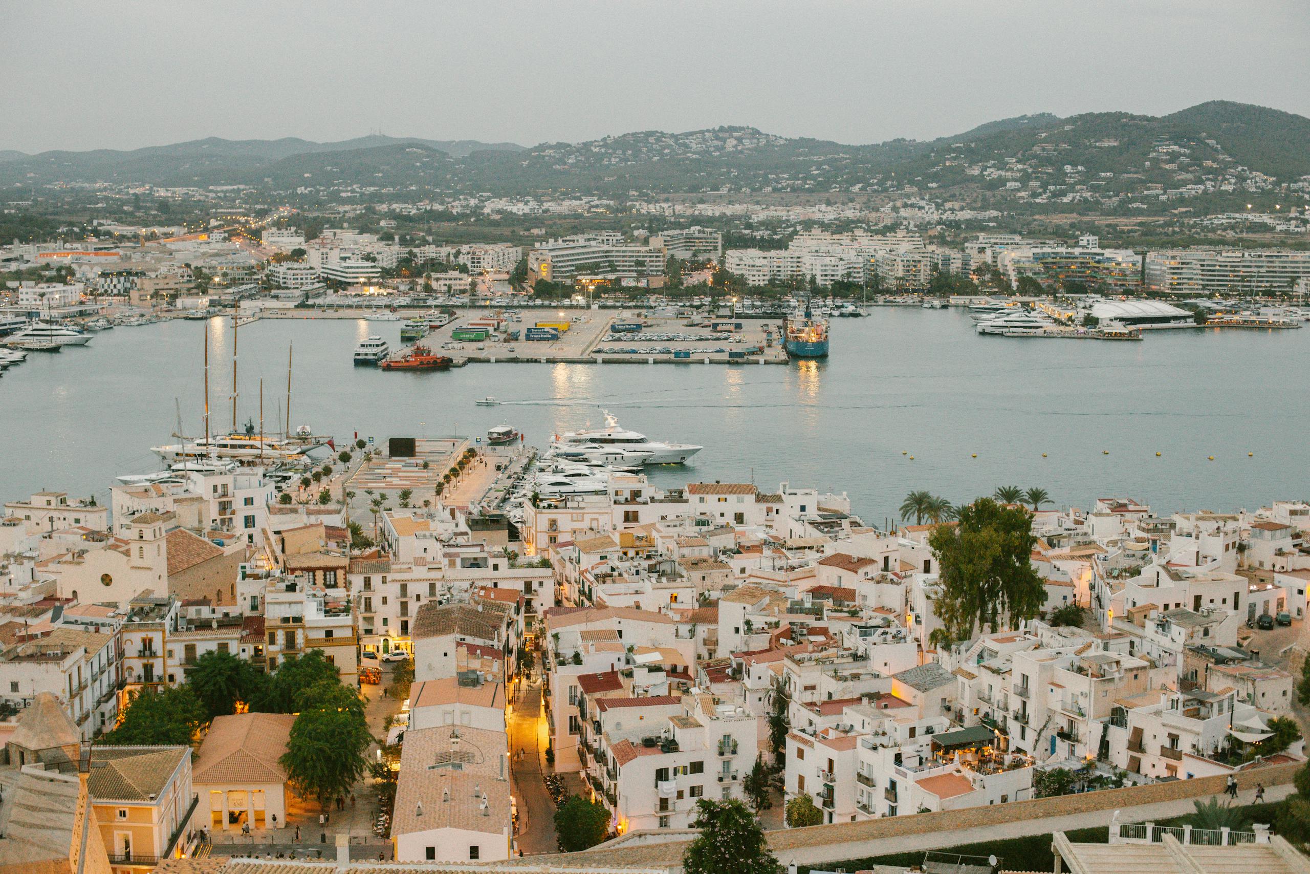 Aerial view of the vibrant Ibiza port with yachts and panoramic cityscape.